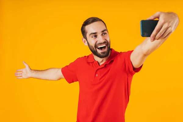 Porträtt av ung man i röd t-shirt skrattar och tittar på Cam — Stockfoto