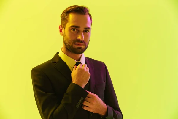 Image of confident young businessman in formal suit touching his tie — Stock Photo, Image