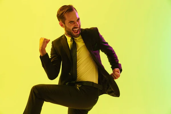 Imagen de joven empresario exitoso en traje formal gritando y haciendo gestos con triunfo —  Fotos de Stock