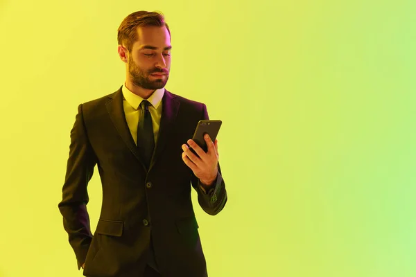 Wizerunek pewności młodego biznesmena w formalnym garniturze trzymania telefonu komórkowego — Zdjęcie stockowe