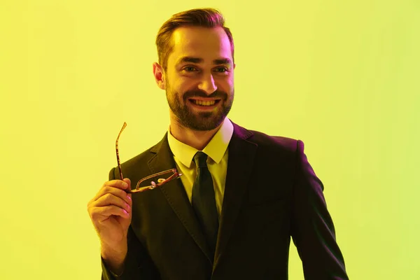 Vidám mosolygó boldog fiatal üzletember pózol elszigetelt világoszöld háttér fal LED neonfények. — Stock Fotó
