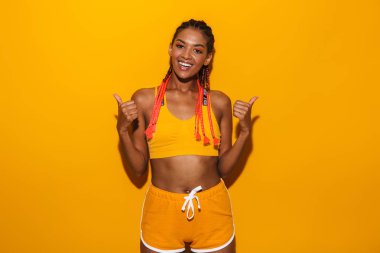 Eşofman giymiş güzel afro-amerikan kadın görüntü başparmak ile gülümseyerek