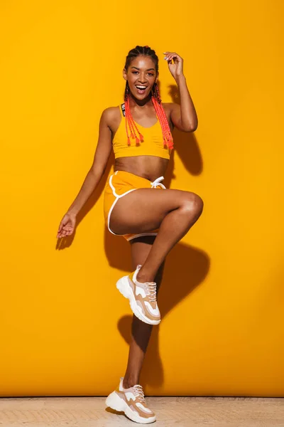 Bild av glad afrikansk amerikansk kvinna klädd i träningsoverall dans och leende på kameran — Stockfoto