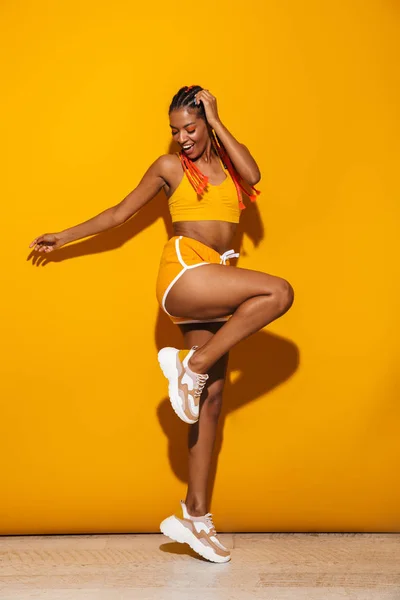 Bild av vacker afrikansk amerikansk kvinna klädd i träningsoverall dansa och skratta — Stockfoto