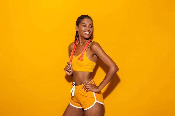 Образ мила афроамериканець жінка, одягнена в спортивний костюм посміхаючись і озираючись на copyspace — стокове фото