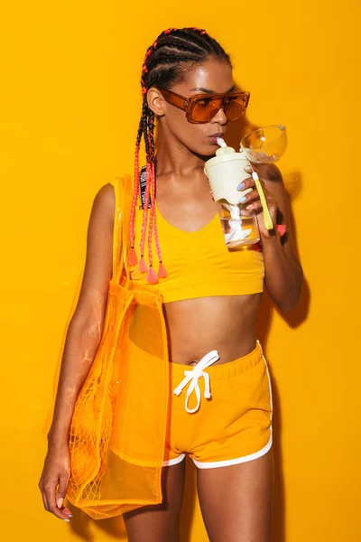 Güneş gözlüğü takan ve plastik bardaktan içen baştan çıkarıcı Afro-Amerikan kadın görüntüsü — Stok fotoğraf