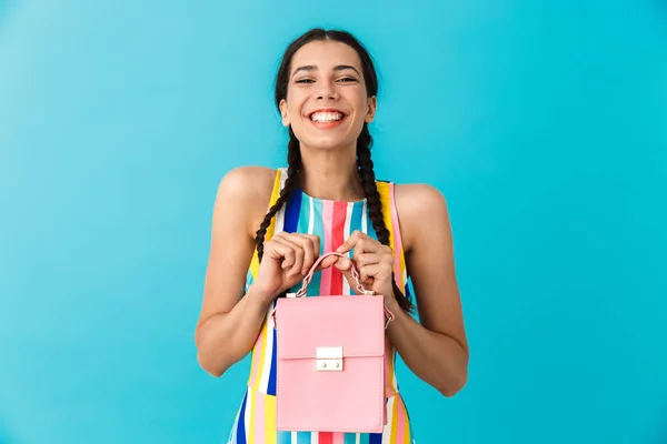 Imagen de mujer caucásica complacida con coletas sosteniendo bolsa rosa y sonriendo — Foto de Stock