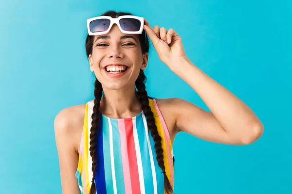 Изображение брюнетки смешной женщины в солнечных очках, смотрящей в камеру и смеющейся — стоковое фото