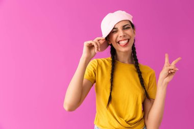 Esmer neşeli kadın şapka giyen gülümseyen ve barış işareti gösteren fotoğraf