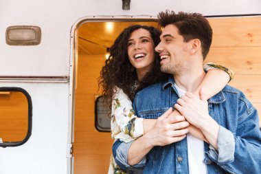 Kamp minibüsünde dururken neşeli genç çift konuşuyor