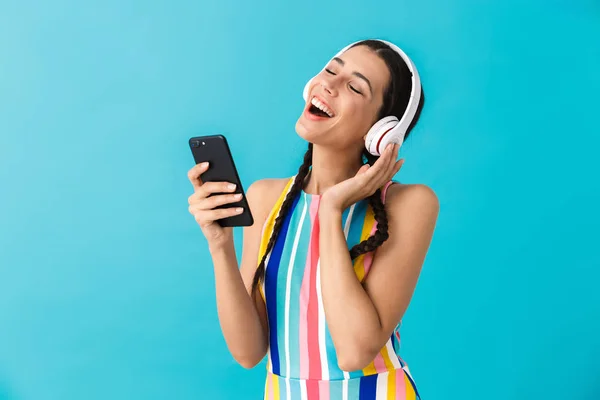 Bild av trevlig lycklig kvinna med slutna ögon med hörlurar och mobiltelefon — Stockfoto
