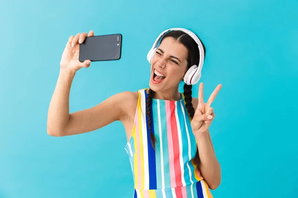 Εικόνα της μελαχρινή όμορφη γυναίκα φορώντας ακουστικά του ματιού κατά τη χρήση του κινητού τηλεφώνου — Φωτογραφία Αρχείου