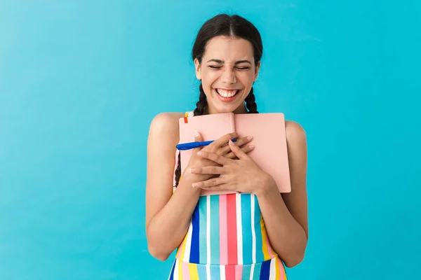 Beeld van blij schattige vrouw met ogen gesloten lachen terwijl het houden van pen en dagboek boek — Stockfoto