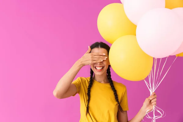 Wizerunek szczęśliwej młodej kobiety uśmiechającej się i pokrywającej jej oczy, trzymając balony powietrzne — Zdjęcie stockowe