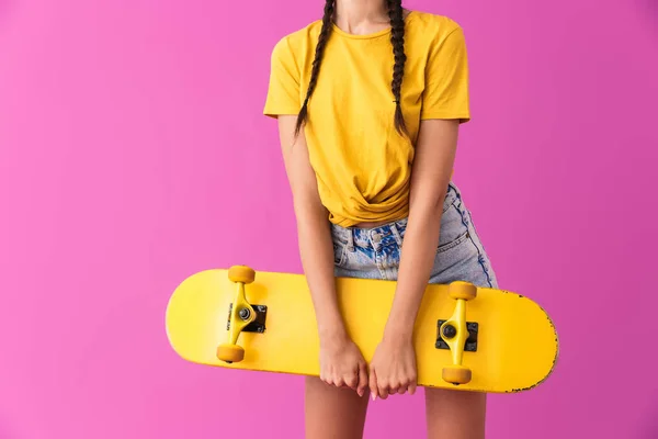 Immagine ritagliata di magra donna caucasica in piedi e in possesso di skateboard — Foto Stock