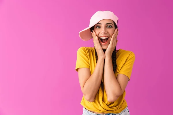 Foto de mujer alegre emocionada usando gorra sonriendo y tocándose las mejillas — Foto de Stock