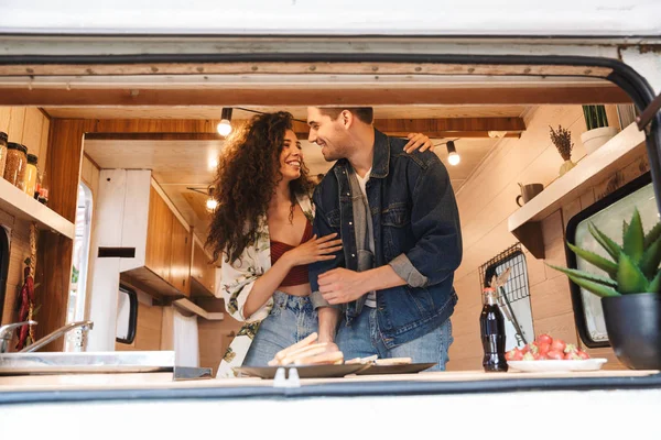 Casal homem e mulher sorrindo enquanto abraçando em reboque casa móvel . — Fotografia de Stock