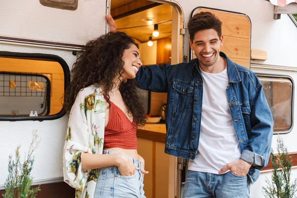 Jovem casal alegre falando enquanto está de pé no campvan — Fotografia de Stock