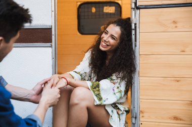 Beyaz çiftin evin yakınında tekerlekli havada birbirlerine bakarken gülümsediği portre