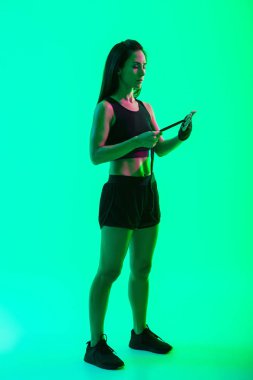 Güzel genç fitness kız arka plan üzerinde izole ayakta