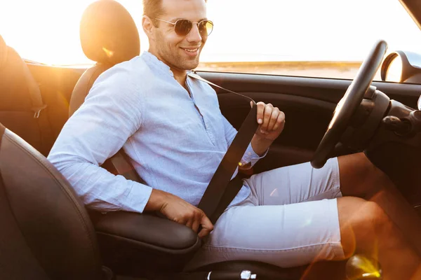 Foto av stilig man bär säkerhetsbälte under körning convertibl — Stockfoto