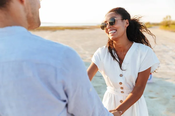 Photo of adorable multiethnic couple smiling and holding hands t — Zdjęcie stockowe