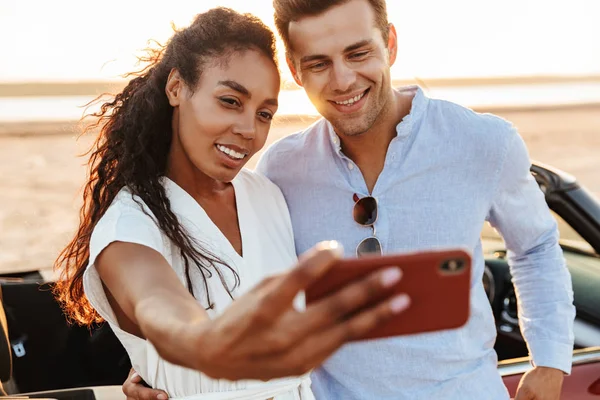 Foto de pareja multiétnica feliz tomando foto selfie en smartph — Foto de Stock