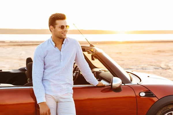 Φωτογραφία του όμορφος Καυκάσιος άνθρωπος στέκεται με Κάμπριο αυτοκίνητο στο b — Φωτογραφία Αρχείου