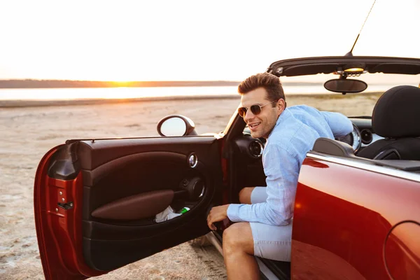 Foto de hombre caucásico guapo saliendo de styli convertible —  Fotos de Stock