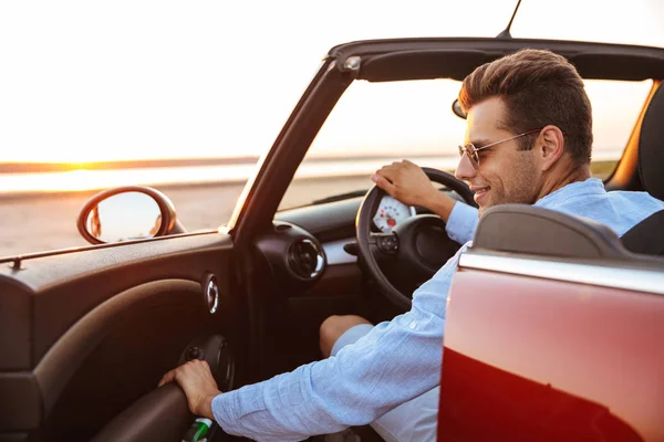Photo of fashionable caucasian man getting out of convertible st — Stock Photo, Image