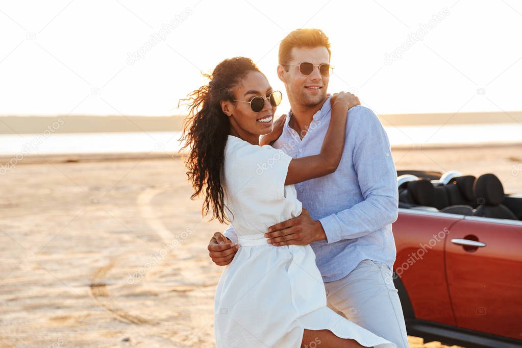 Photo of gorgeous multiethnic couple smiling and hugging togethe