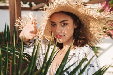 Tropik bitkiler üzerinde güzel bir güneşli sabah yürüyüş plajda Amazing genç güzel kadın.