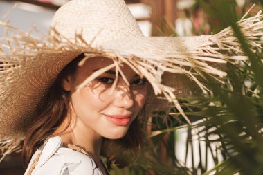 Tropik bitkiler üzerinde güzel bir güneşli sabah yürüyüş plajda Amazing genç güzel kadın.