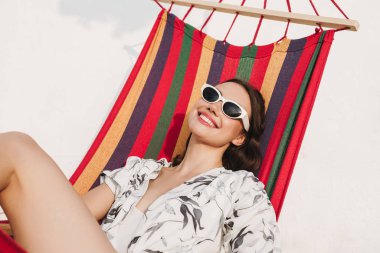 Sahilde güzel kadın bir hamak üzerinde poz