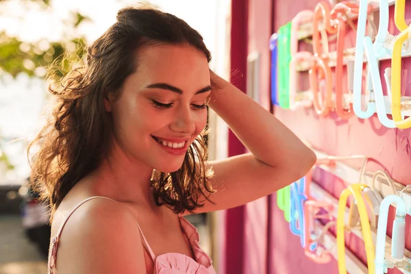 Allegro sorridente giovane bella donna alla festa in spiaggia vicino luminoso muro colorato led in bar caffè . — Foto Stock