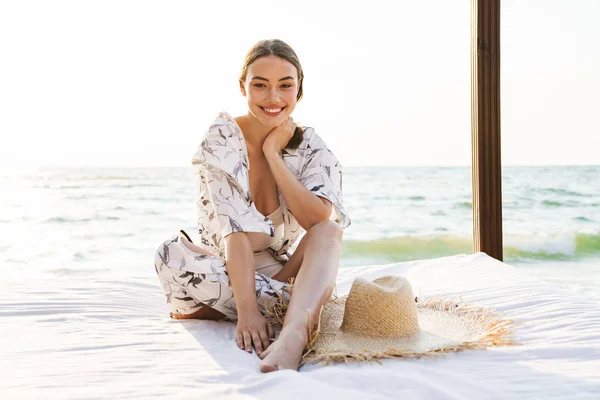 아름다운 화창한 아침에 포즈를 취하는 해변에서 기쁘게 젊은 아름다운 여자. — 스톡 사진