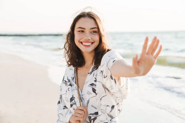 Cheery positive happy young beautiful woman at the beach walking in a beautiful sunny morning. — Stock Photo, Image