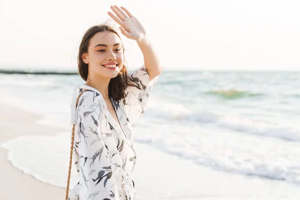 아름다운 화창한 아침에 걷는 해변에서 쾌활한 긍정적 인 행복한 젊은 아름다운 여자. — 스톡 사진