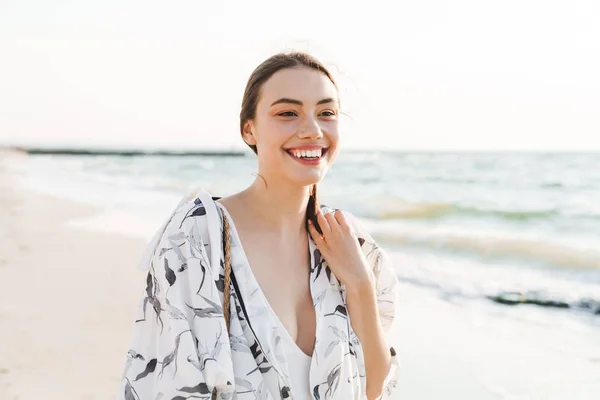 Fröhlich positive glücklich junge schöne Frau am Strand zu Fuß in einem schönen sonnigen Morgen. — Stockfoto