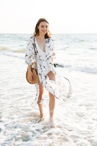 Cheery positive happy young beautiful woman at the beach walking in a beautiful sunny morning. — Stock Photo, Image