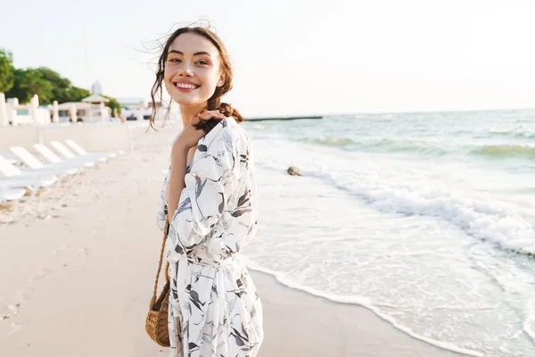 아름다운 화창한 아침에 걷는 해변에서 쾌활한 긍정적 인 행복한 젊은 아름다운 여자. — 스톡 사진