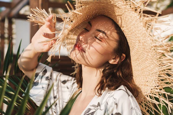 Positive glückliche junge schöne Frau am Strand, die an einem schönen sonnigen Morgen über tropische Pflanzen spaziert. — Stockfoto