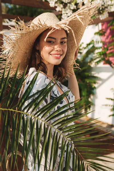 열대 식물을 통해 아름다운 화창한 아침에 걷는 해변에서 긍정적 인 행복한 젊은 아름다운 여성. — 스톡 사진