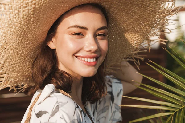 Positive glückliche junge schöne Frau am Strand, die an einem schönen sonnigen Morgen über tropische Pflanzen spaziert. — Stockfoto