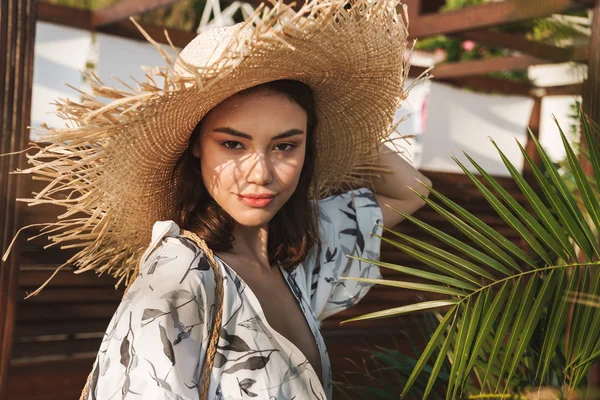Úžasná mladá krásná žena na pláži v nádherném slunném jitra nad tropickými rostlinami. — Stock fotografie