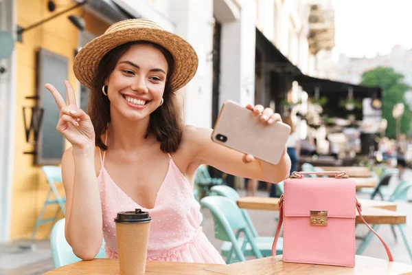 Afbeelding van charmante brunette vrouw glimlachend en het nemen van selfie-foto — Stockfoto