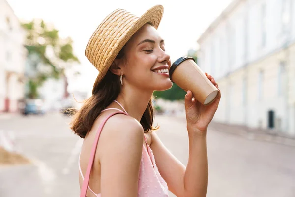 Valokuva lähikuva onnellinen nuori nainen yllään kesäolki hattu drin — kuvapankkivalokuva