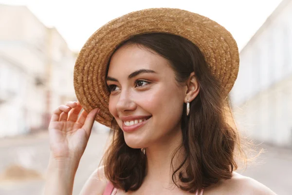 Yazlık hasır şapka giyen göz alıcı genç kadının fotoğrafı 