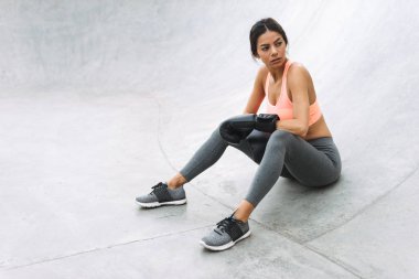 Açık havada beton zeminde oturan boks eldivenciddi genç kız görüntü