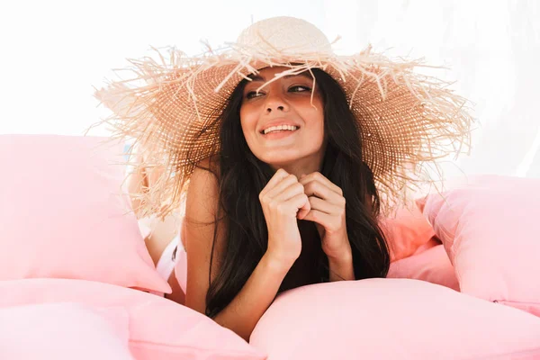 Imagem da jovem mulher satisfeita em maiô e chapéu de palha sorrindo w — Fotografia de Stock